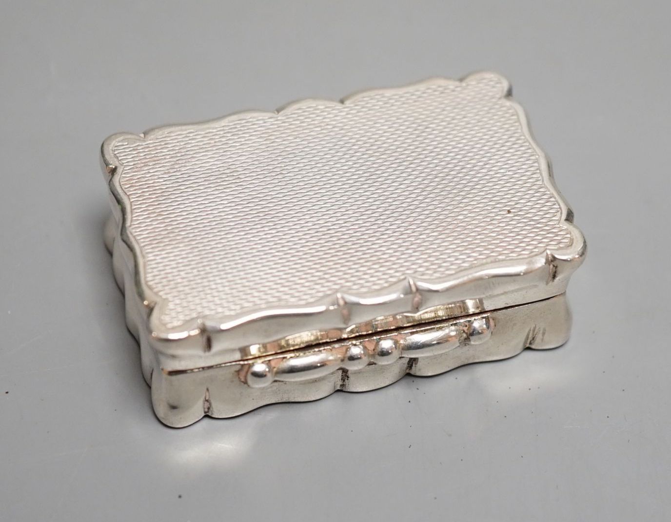 A 1930’s part engine turned silver snuff box, with engraved initials, Birmingham, 1937, 49mm.